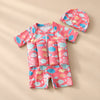 TibaToes™ FloatPal Kids Buoyancy Swimsuit photographed with its matching design and colours on a warm beige studio surface.