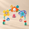Ocean Friends stroller play arch with crab mirror, flower and hanging ocean toys on a warm beige studio surface.