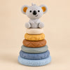Koala stacking tower with six textured rings in pale blue, slate blue, sage, brown, yellow and ivory.