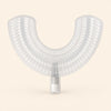 A translucent white U-shaped EasyBrush replacement mouthpiece with bristle rows and a cylindrical connector on warm beige.