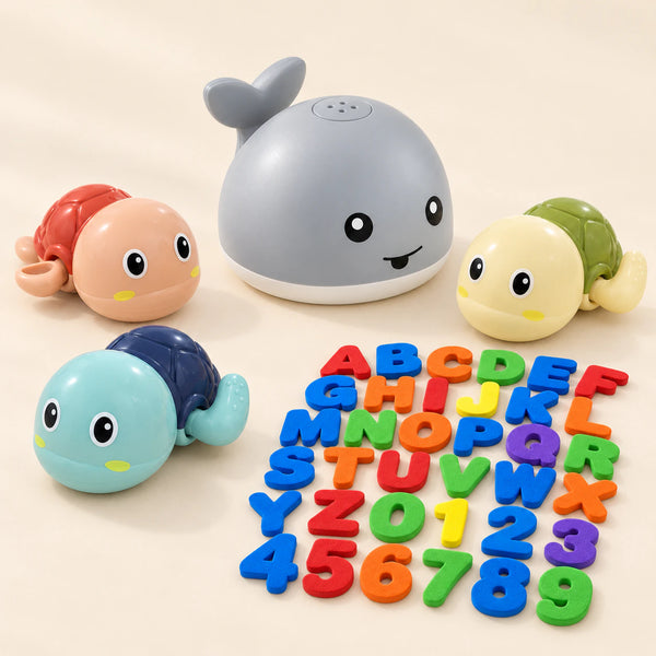 One grey whale sprinkler, three wind-up turtles and the complete foam alphabet and number set on a calm pale beige background.
