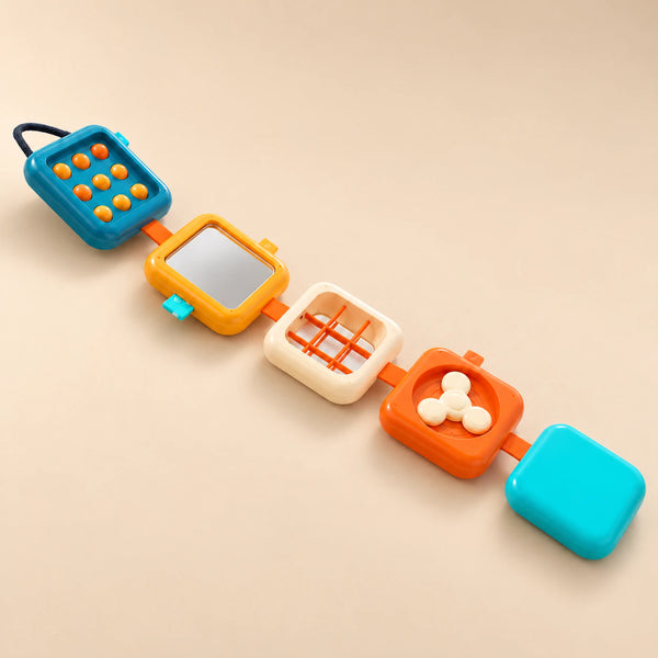 The five connected activity panels unfolded on a sunlit beige table, showing buttons, mirror, grid and spinner.