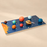 Solar System Planet Puzzle Board with eight raised planet pieces on a warm beige studio surface.