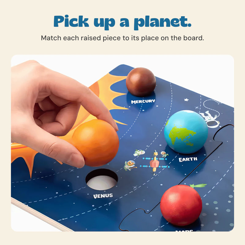 Hand lifting the Venus piece from its matching place on the solar system board.