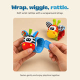 Hands showing the wraparound strap on the blue zebra wrist rattle.