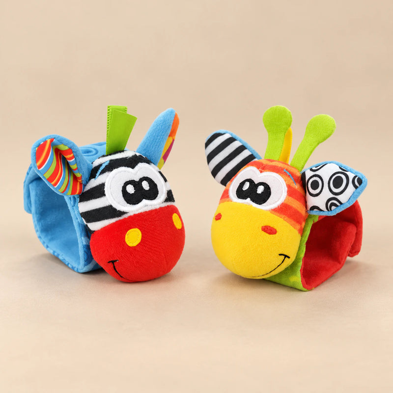 Two colourful animal wrist rattles on a warm beige background.
