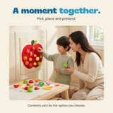 Original photograph of a child placing toy food on the red apple board beside an adult, with pretend food on the table. Contents vary by selected option.