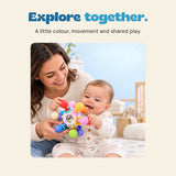 A mother and baby hold the colourful sensory ball together, showing its textured ends and sliding rings.