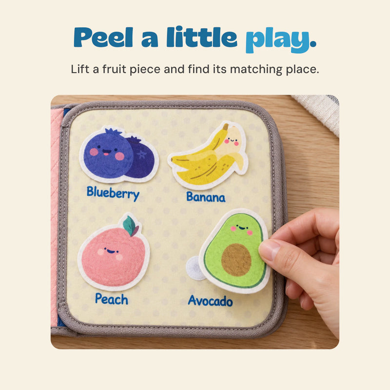 Adult hand lifting the smiling avocado piece from the fruit activity page, beside the blueberry, banana and peach pieces.