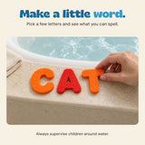 An adult hand places the foam letter T beside C and A to spell CAT on the bath ledge.