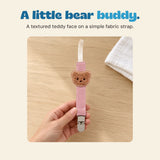 Adult hand holding the pink Bear Buddy clip, with its full cream loop, brown teddy detail and grey clasp visible.