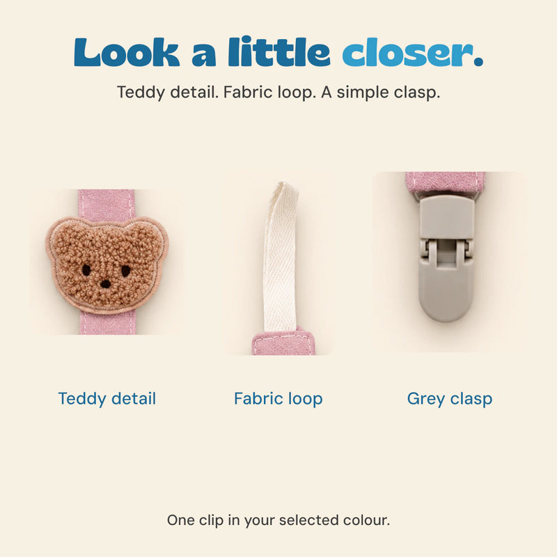 Close-up details of the brown textured teddy applique, cream fabric loop and grey clasp on the pink pacifier clip.