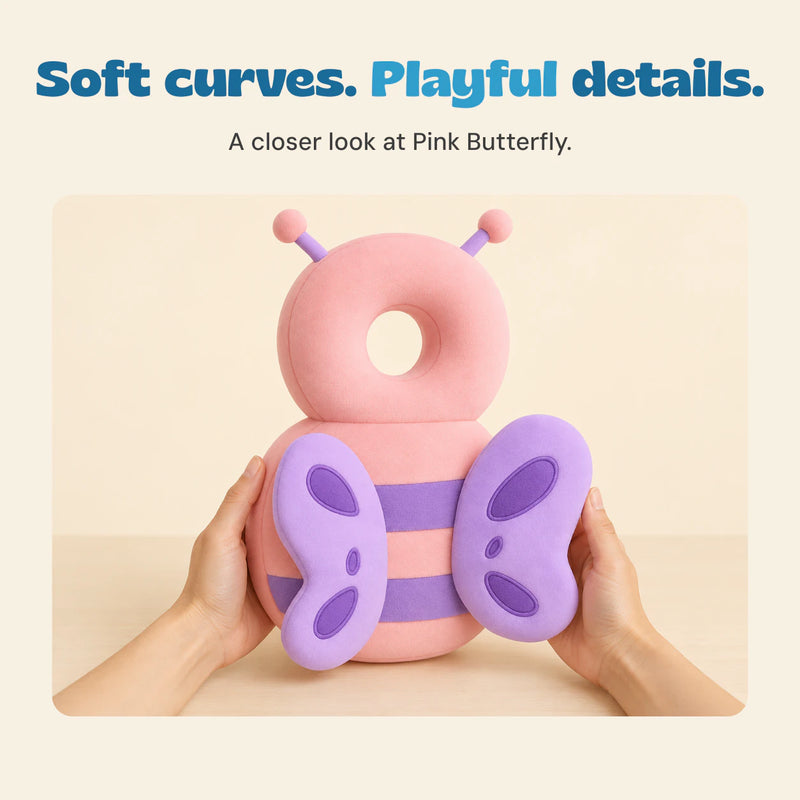 Two adult hands hold the pink butterfly cushion, with its ring-shaped top and purple wings visible.
