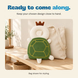 Green Turtle cushion standing in front of a plain canvas tote on a pale wooden bench.