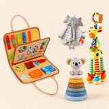 Animal Orange busy board with a grey elephant snuggle blanket, blue-neck yellow giraffe rattle and six-ring koala stacking tower on a pale beige background.