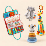 Rocket Green Plus busy board with a grey elephant snuggle blanket, blue-neck yellow giraffe rattle and six-ring koala stacking tower on a pale beige background.