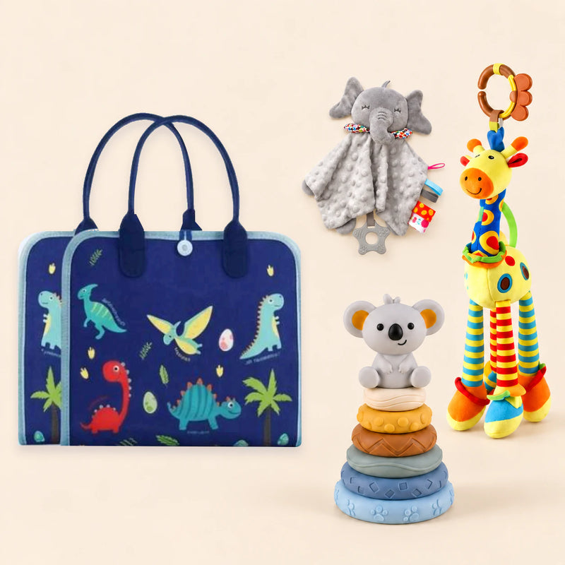 Dinosaur Blue Plus busy board with a grey elephant snuggle blanket, blue-neck yellow giraffe rattle and six-ring koala stacking tower on a pale beige background.