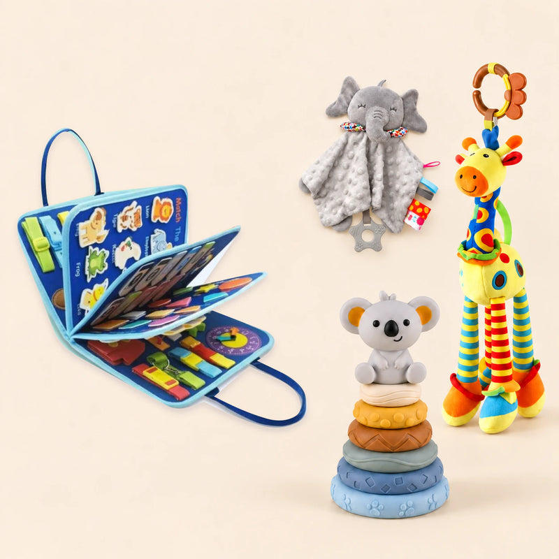 Vehicle Blue Plus busy board with a grey elephant snuggle blanket, blue-neck yellow giraffe rattle and six-ring koala stacking tower on a pale beige background.