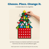 A cropped adult hand lifts the removable red felt heart from the Christmas countdown tree, with a simple decorating idea.