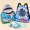 Summer Swim and Snuggle Gift with mint and blue clip-on goggles, blue shark hooded poncho and blue astronaut swim bag on a warm beige studio surface.