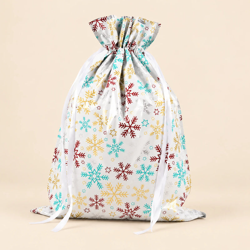 TibaToes Christmas Gift Bag, Large, Snowflake Confetti White, ribbon closure on a warm beige studio background.