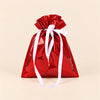 TibaToes Christmas Gift Bag, Small, Jolly Red, ribbon closure on a warm beige studio background.
