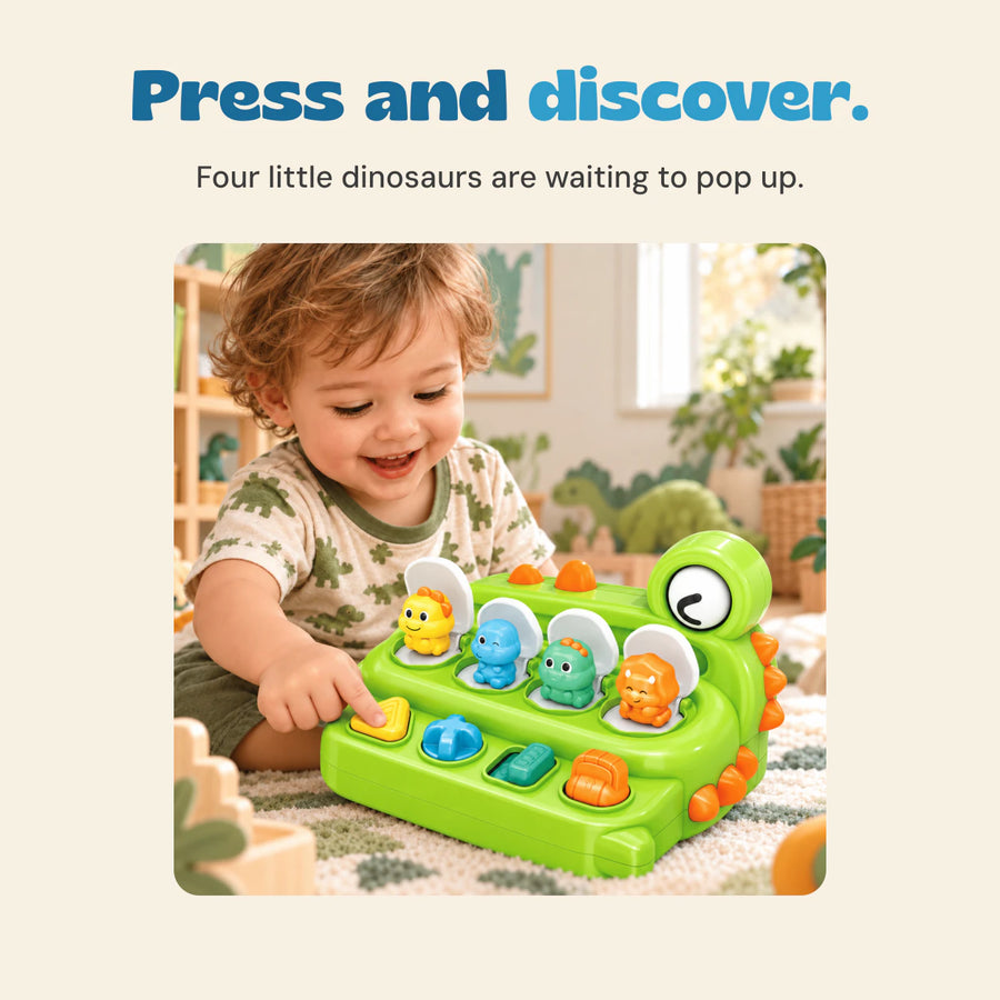 A child presses the yellow button on the green dinosaur toy, with four colourful dinosaurs visible in open compartments.
