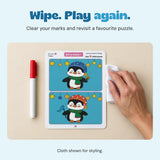 Adult hand with a white cloth beside the unchanged reusable penguin puzzle and capped marker.