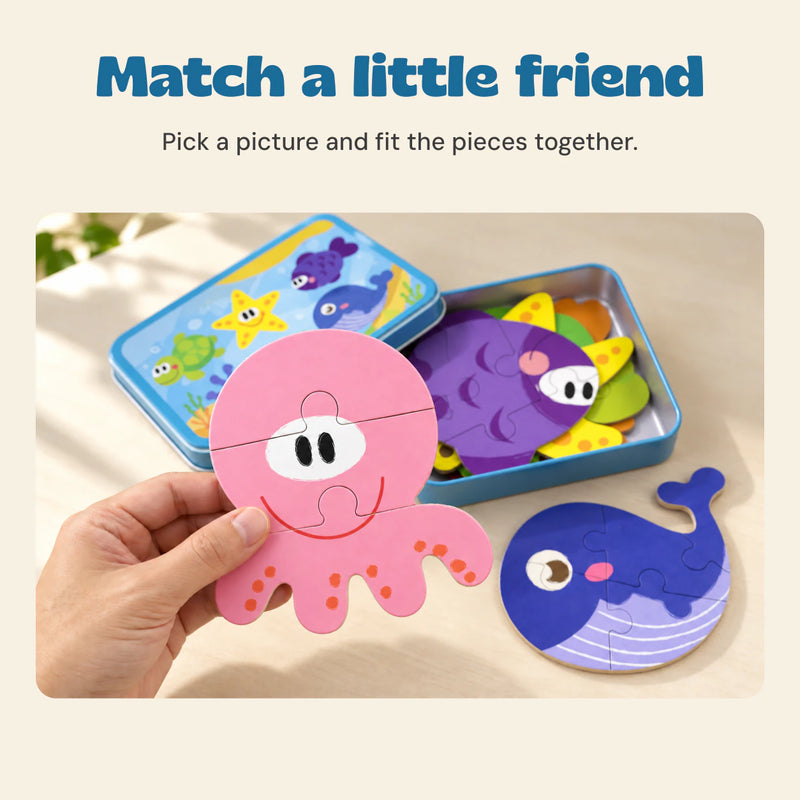 An adult hand holds the pink octopus puzzle beside its blue storage tin and matching sea-animal puzzles.