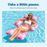 Adult reclining on the DriftLeaf Berry Palm pool hammock with head, arm and leg support.