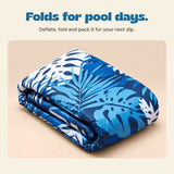 DriftLeaf Ocean Palm pool hammock deflated and folded on a warm beige studio background.