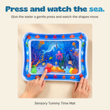Hands press the blue-bordered ocean water mat to move its floating shapes.