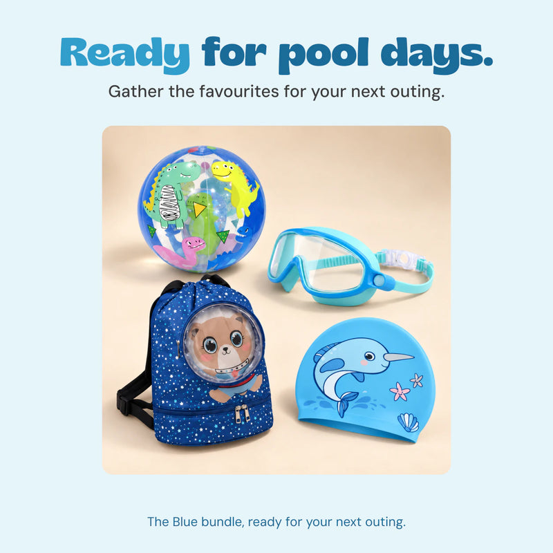 The blue bundle’s dinosaur beach ball, blue goggles, space-bear backpack and narwhal swim cap sit together beside a swimming pool.