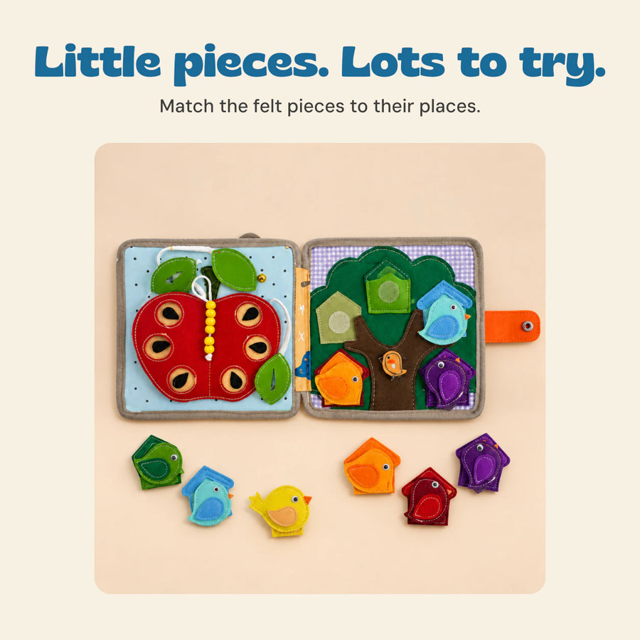 Open BusyBuddy felt activity book with apple, tree and birdhouse pages and matching bird pieces.