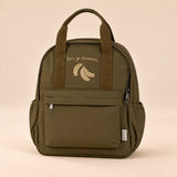 Little Explorer Large Backpack. Little Banana Brown. Clean product photograph on a warm beige studio surface.