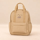 Little Explorer Large Backpack. Honey Bear Cream. Clean product photograph on a warm beige studio surface.