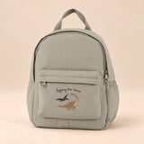 Little Explorer Large Backpack. Dino Soft Grey. Clean product photograph on a warm beige studio surface.