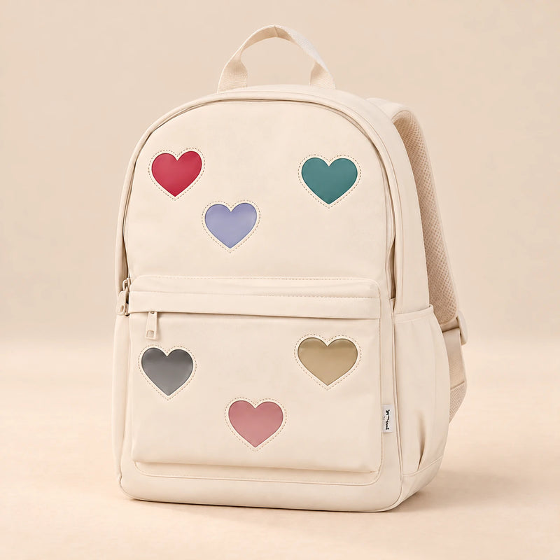 Little Explorer Large Backpack. Sweetheart Cream. Clean product photograph on a warm beige studio surface.
