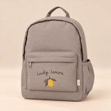 Little Explorer Large Backpack. Lucky Lemon Taupe. Clean product photograph on a warm beige studio surface.
