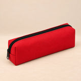 Everyday Pencil Pouch. Cherry Red. Clean product photograph on a warm beige studio surface.