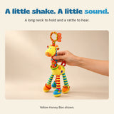An adult hand holds the Pebble Grey elephant rattle by its striped ring body.