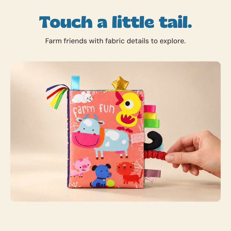 An adult hand touches the red textured tail on the Farm Fun cloth book while its exact cover artwork stays visible.