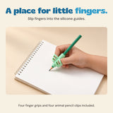 A hand uses the mint silicone finger grip on a green pencil over a notebook.
