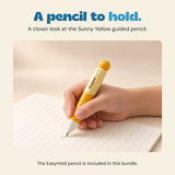 A hand writes on ruled paper with the cream and yellow EasyHold pencil.