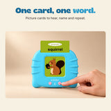 A hand presses a button on the blue talking flashcard reader with a squirrel card inserted.