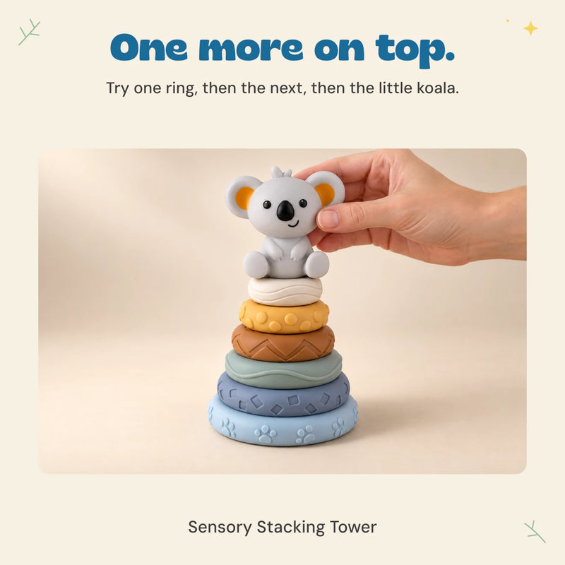 An adult hand places the koala topper on the six textured rings.