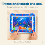 Hands gently press the blue ocean water mat to move its floating shapes.