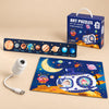 GalaxyGlow USB projector, Space Blue solar system puzzle strip, and 24-piece Space Adventure floor puzzle with its box on warm beige.
