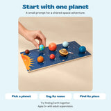 One hand places the raised Earth piece on the Solar System Planet Puzzle Board. Pick a planet, say its name and find its place.