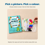 A hand choosing the green marker from the twelve-colour pouch beside the closed Frog Drawing Adventure workbook.